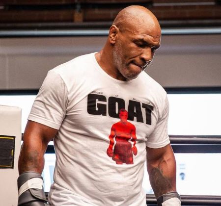 Mike Tyson poses for a picture in a 'goat' t-shirt.